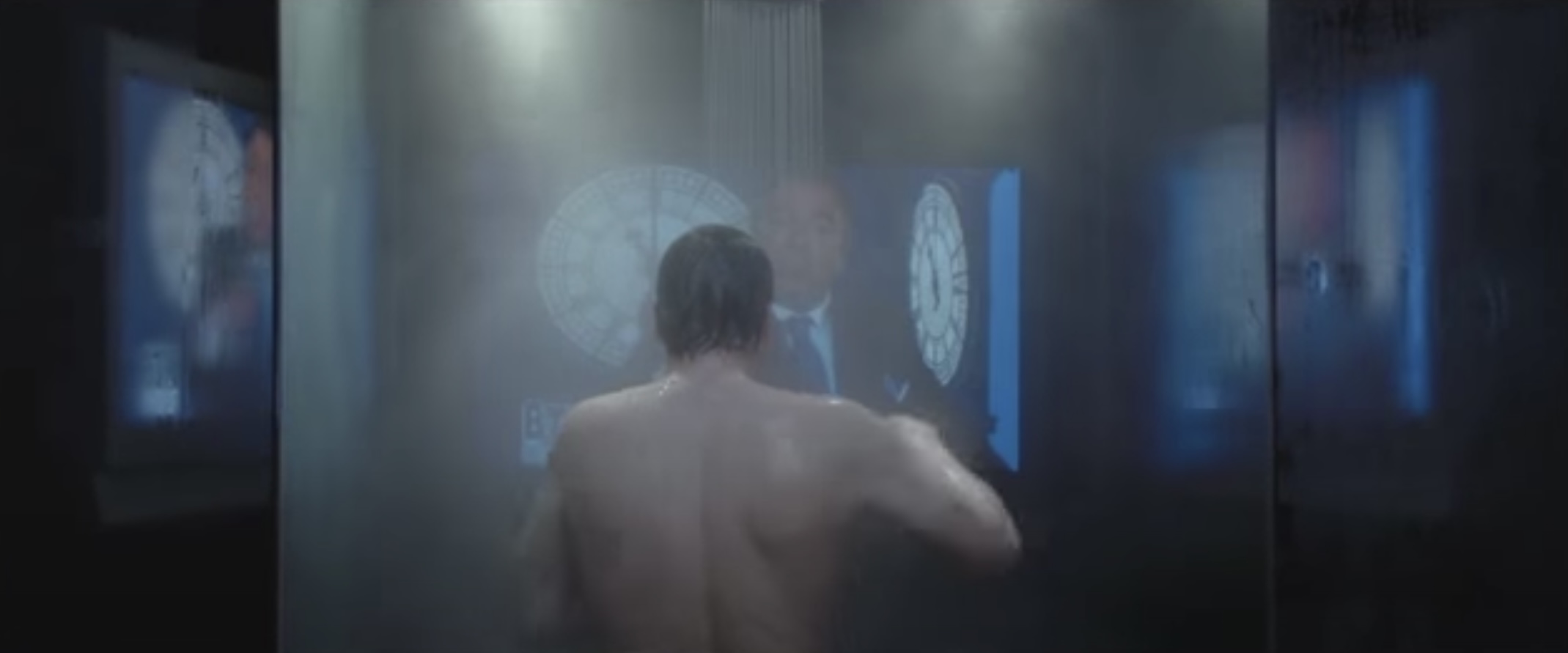 Takduschar och underhållning i en scen från V for Vendetta där nyhetsankaret står och duschar omgiven av tv-apparater.